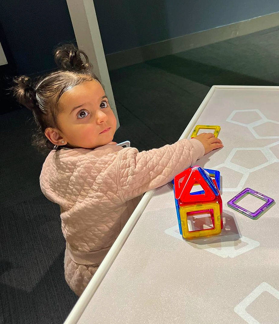 Athena is registered to the contest to win money with this photo: baby, baby_playing_with_toys, box, child, flooring, fun, person, plastic, play, room, toddler, toy, toy_block, wood