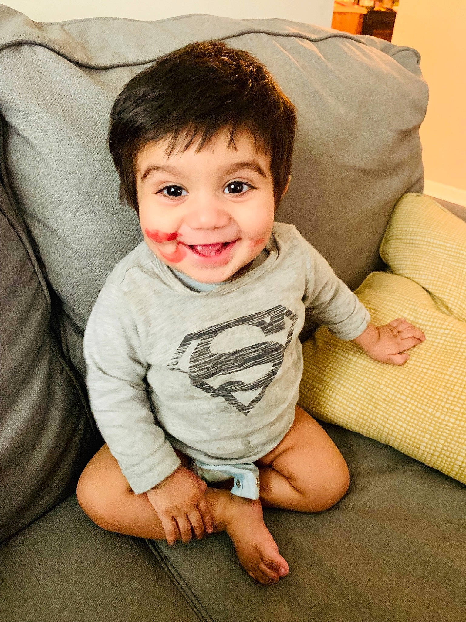 Hadi is registered to the contest to win money with this photo: baby, cheek, child, chin, eye, face, facial_expression, floor, flooring, happy, head, joy, leg, nose, person, sitting, skin, sleeve, smile, t_shirt