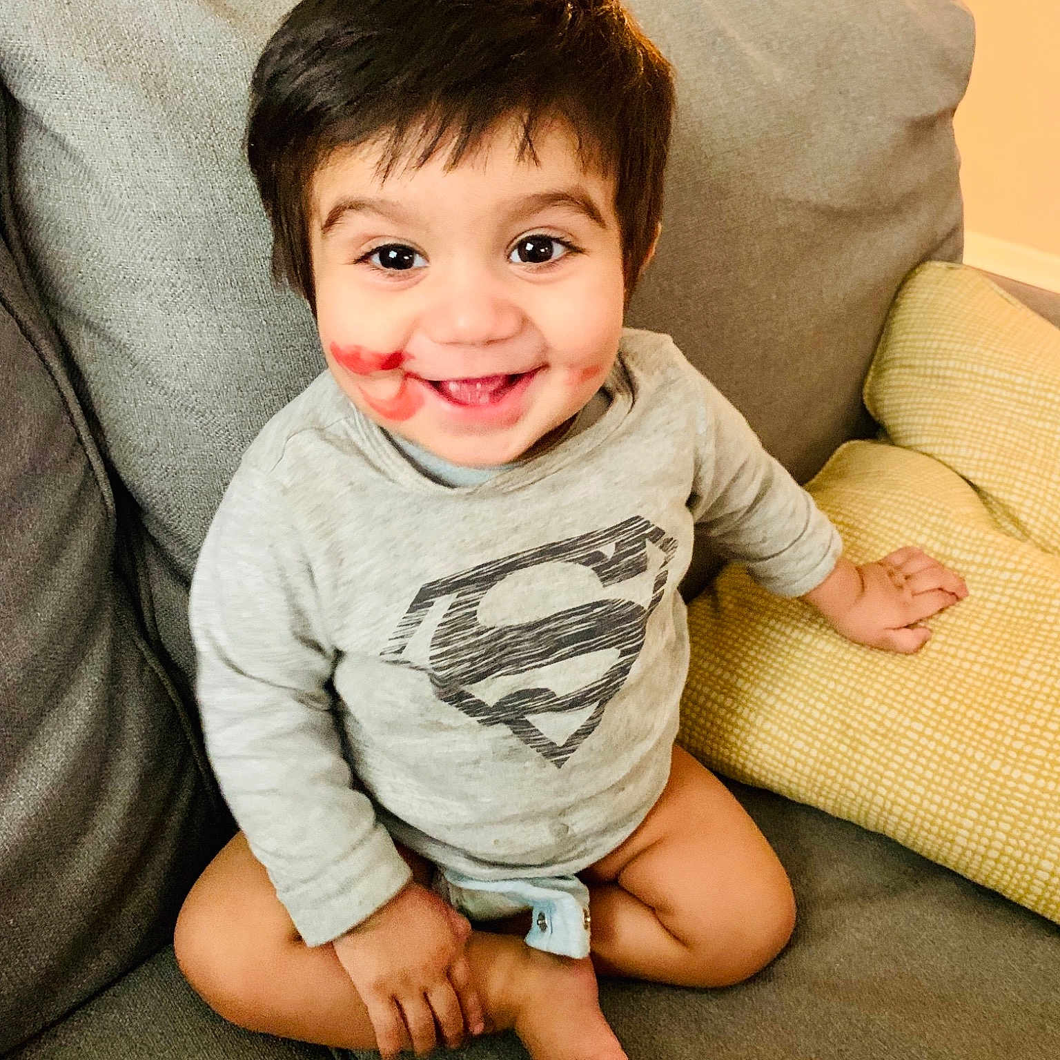 Hadi is registered to the contest to win money with this photo: baby, cheek, child, chin, eye, face, facial_expression, floor, flooring, happy, head, joy, leg, nose, person, sitting, skin, sleeve, smile, t_shirt