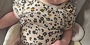 Eliana is registered to the contest to win money with this photo: baby, infant, child, onesie, clothing, pattern, floral_pattern, polka_dot, blanket, cushion, seat, soft, cute, face, head, skin, expression, lying_down, indoors, relaxed