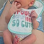 newborn, baby, infant, bib, fingers, feet, diaper, tattoo, jeans, ripped_jeans, person, lap, footwear, casual_shoes, skin, hand, cute, relaxing, outdoor, closeup