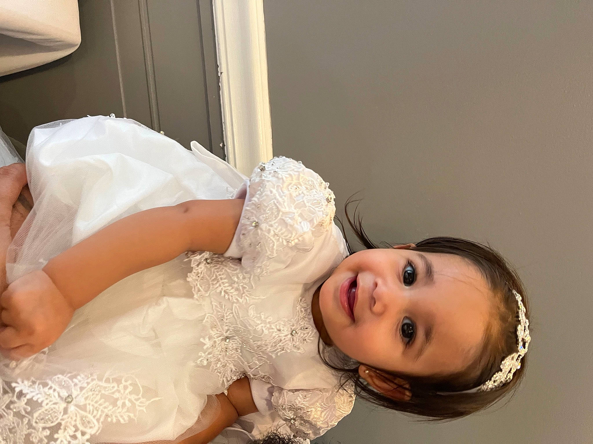 Isabella is registered to the contest to win money with this photo: beauty, bridal_accessory, bridal_clothing, bridal_party_dress, bridal_veil, bride, dress, embellishment, eyelash, flash_photography, gown, happy, headpiece, human_body, joy, leg, person, skin, smile, toddler