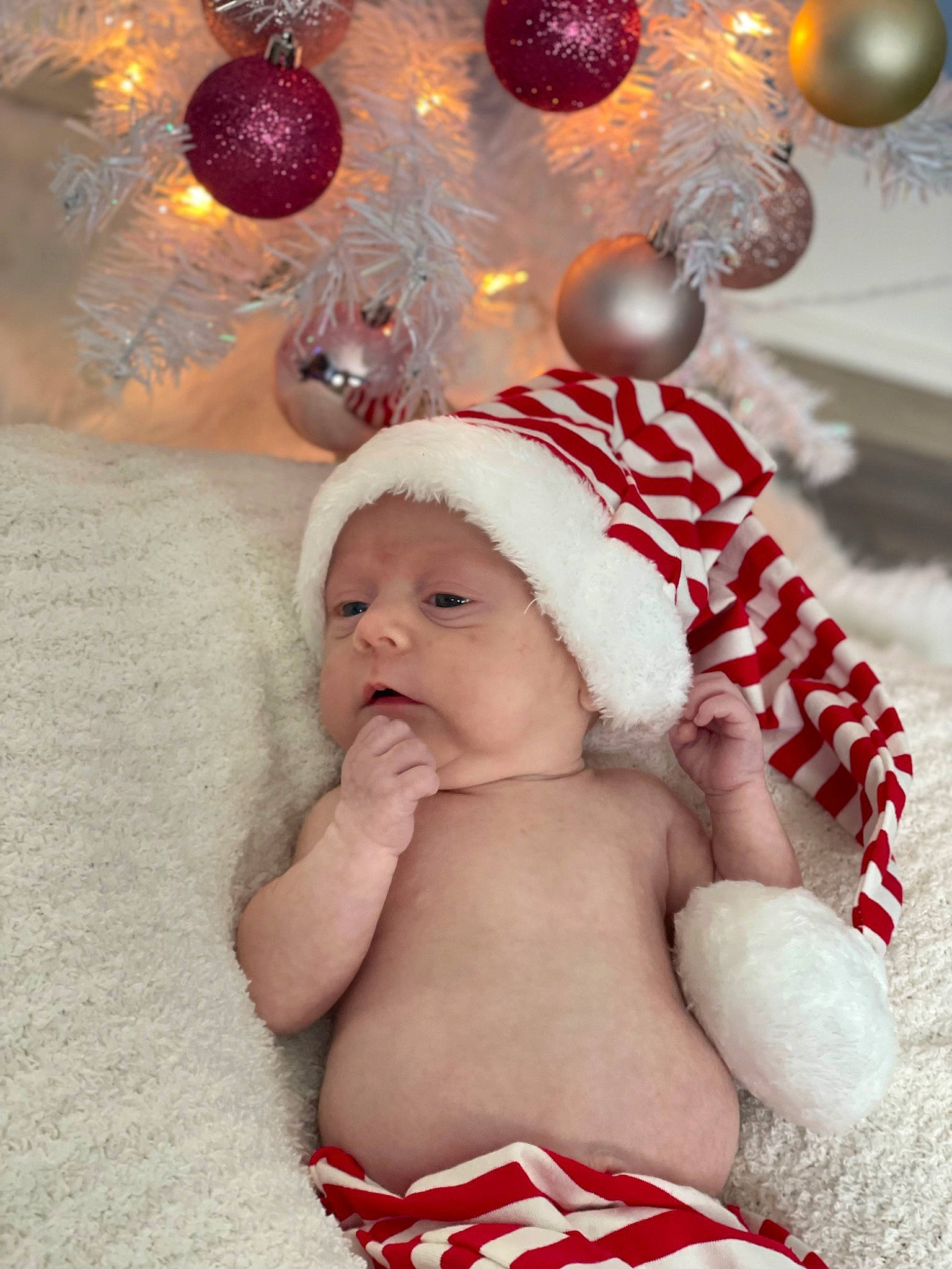 Emersyn joined the competition — help win amazing prizes! baby, baby_toddler_clothing, carmine, child, christmas, christmas_decoration, christmas_eve, christmas_ornament, event, fictional_character, fun, happy, hat, headwear, holiday, holiday_ornament, light, ornament, person, red