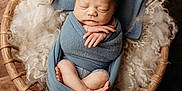 Adelaide joined the competition — help win amazing prizes! newborn, baby, swaddled, sleeping, basket, blue_wrap, headband, wooden_floor, fluffy_wool, peaceful, infant, portrait, cozy, cute, small_hands, tiny_feet, soft_texture, resting, indoors, warm_lighting