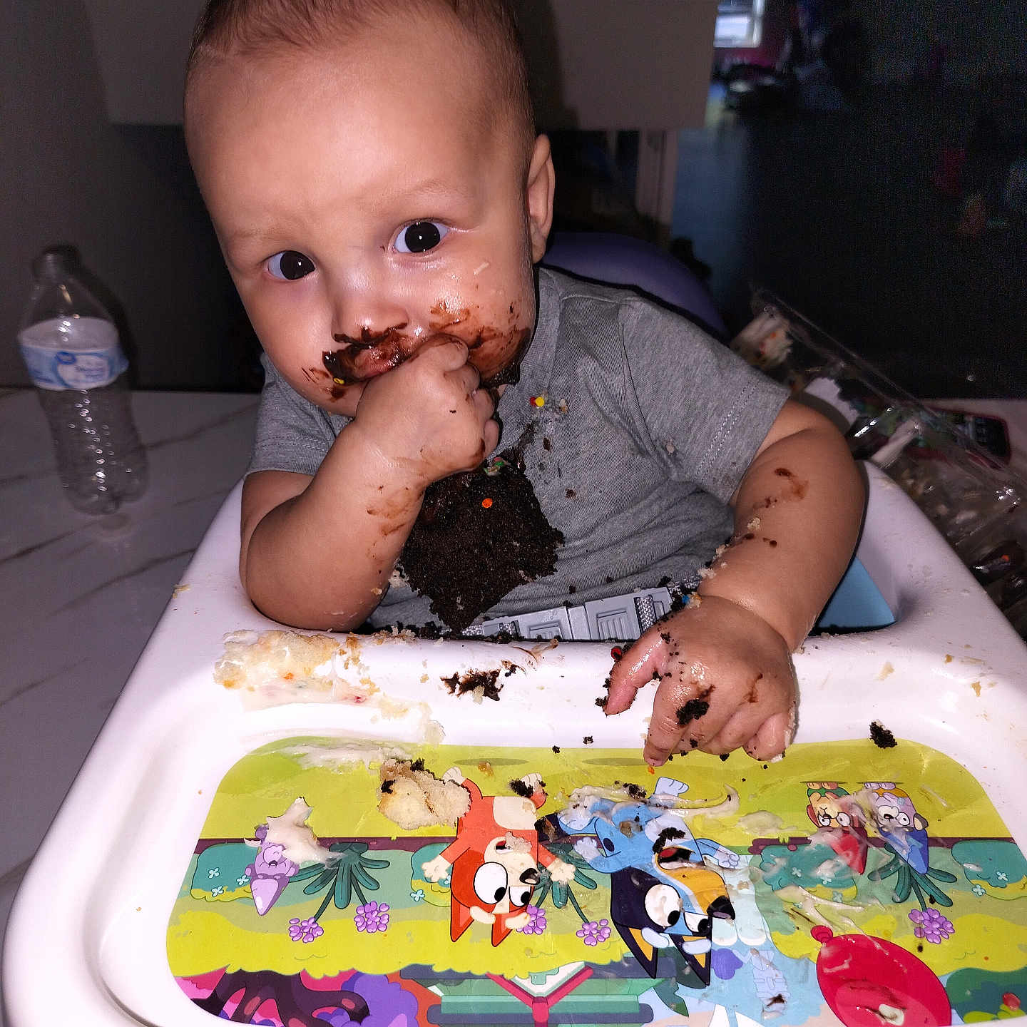 Jayden is registered to the contest to win money with this photo: baby, bodypart, bottle, couch, cream, cutlery, dessert, eating, face, finger, food, furniture, hand, head, icing, person, photography, portrait, spoon, waterbottle