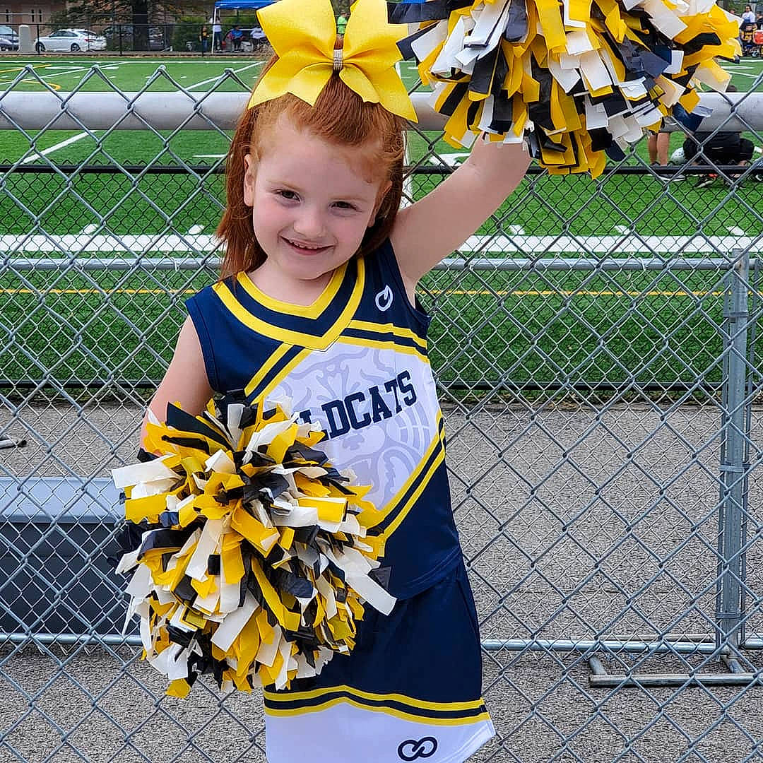 Abigael is registered to the contest to win money with this photo: cheering, cheerleading, cheerleading_uniform, child, competition_event, joy, person, plant, player, pom_pom, product, sports, sports_uniform, team, team_sport, uniform, wheel, yellow