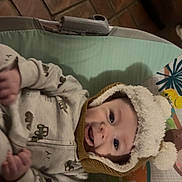 Kagen is registered to the contest to win money with this photo: baby, infant, hat, pom_pom, smile, happy, clothing, baby_seat, cushion, pattern, floor, tile, indoor, child, cute, portrait, warm, cozy, person, expression