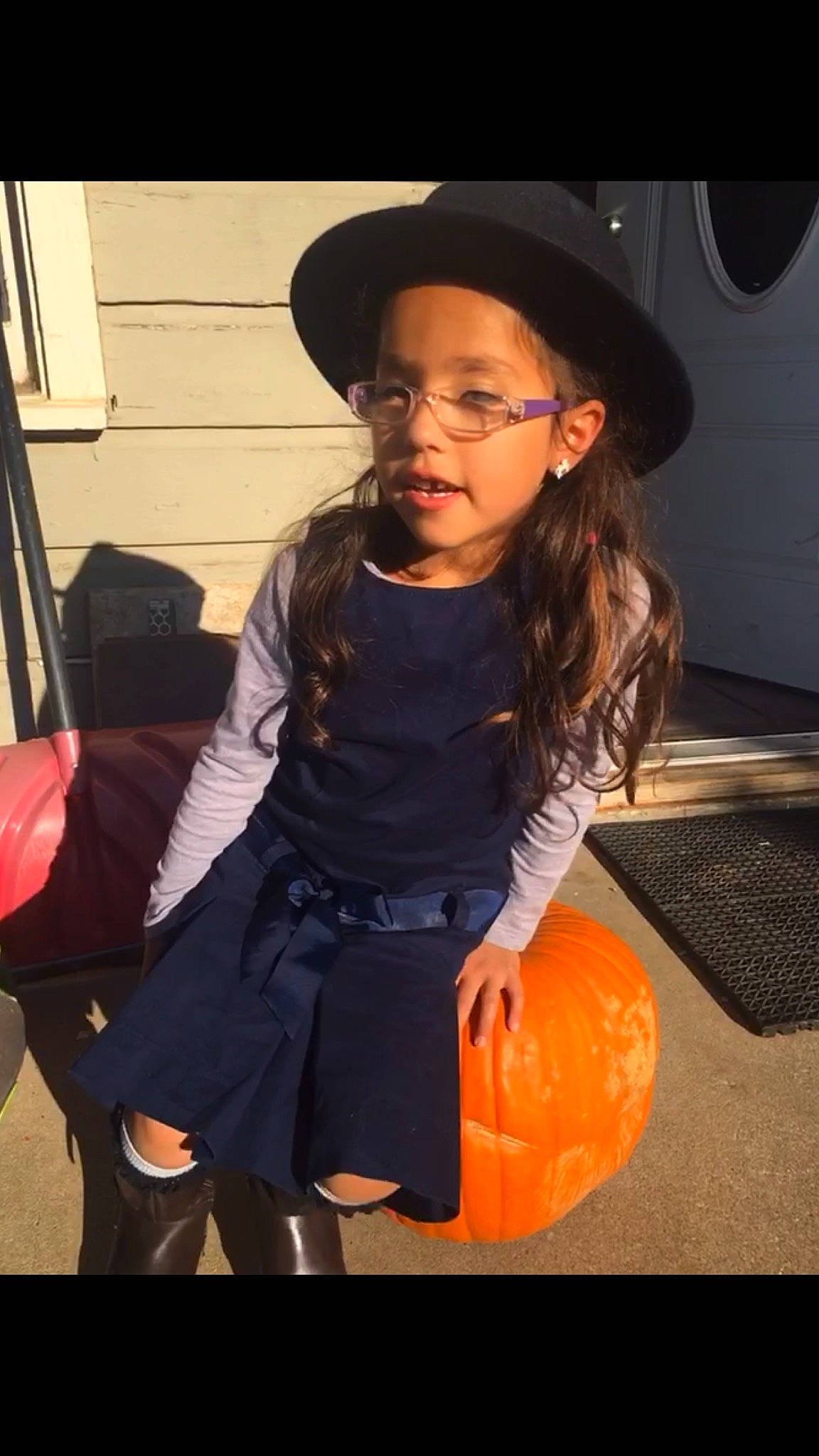 Amelía Gabriela is registered to the contest to win money with this photo: brown_hair, calabaza, cap, child, eyewear, fashion_accessory, flash_photography, flooring, fun, glasses, happy, hat, headgear, headwear, luxury_vehicle, person, pumpkin, sitting, sun_hat, toddler