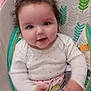 baby, child, smiling, blue_eyes, white_shirt, pink_pants, heart_pattern, baby_seat, colorful, indoor, cute, happy, infant, face, portrait, movement, hand, patterned, comfort, young