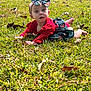 Serenity is registered to the contest to win money with this photo: baby, child, grass, outdoor, nature, headband, bow, red_clothing, skirt, infant, cute, lying_down, greenery, leaves, sunlight, portrait, young_child, baby_girl, grass_field, daylight