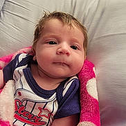 Skyler is registered to the contest to win money with this photo: baby, infant, blanket, pillow, clothing, face, person, portrait, indoors, cute, child, young, resting, cozy, soft, sleepwear, pink, white, blue, relaxed