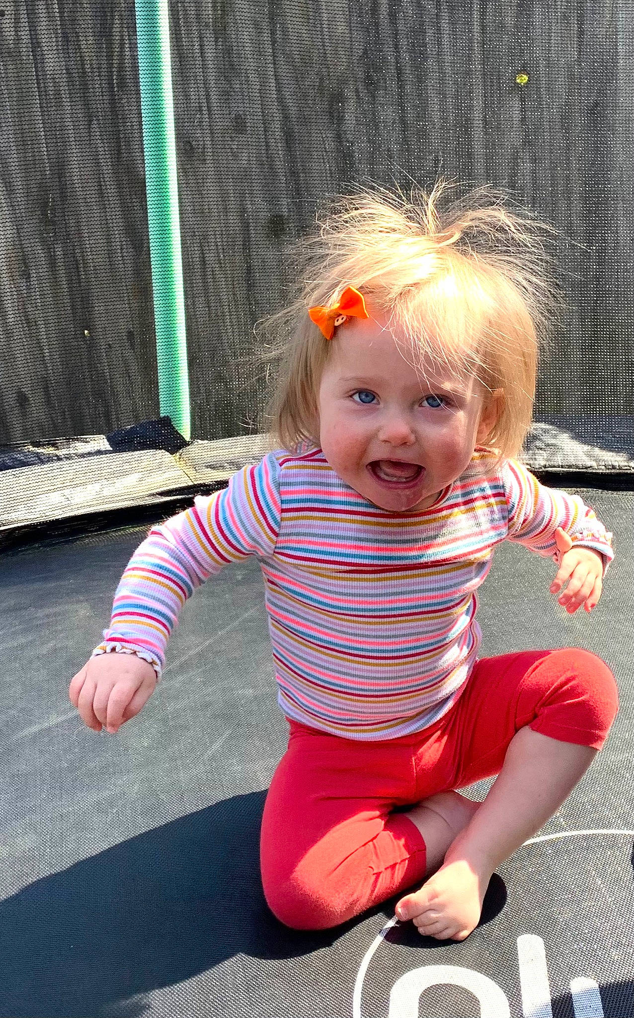 Maisy is registered to the contest to win money with this photo: baby, baby_toddler_clothing, cheek, child, chin, dress, eye, face, fun, grass, happy, pattern, person, photograph, pink, sitting, skin, sleeve, smile, t_shirt