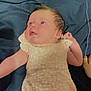 baby, infant, child, blue_eyes, peach_outfit, lying_down, fabric_background, soft_texture, cute, newborn, portrait, skin, hand, face, clothing, sleepwear, young_child, human, head, expression