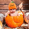 baby, child, infant, pumpkin, halloween, costume, hat, orange, portrait, outdoor, autumn, fall, rustic, wooden_background, straw, farm, seasonal, sitting, wide_eyed, photography