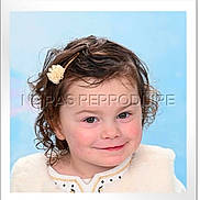 Lucie a rejoint le concours — aidez-le/la à gagner de superbes lots ! child, toddler, portrait, smile, curly_hair, hair_clip, blue_background, studio_portrait, watermark, white_border, framed_photo, rosy_cheeks, green_eyes, face, headshot, clothing, fur_vest, photograph, cute, portrait_smile