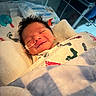Jesse joined the competition — help win amazing prizes! newborn, baby, infant, smile, hospital, blanket, swaddled, medical, nasal_tube, bed, sleeping, soft_lighting, person, cute, closeup, healthcare, footprints_pattern, comfort, resting, indoors