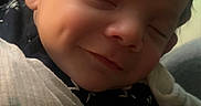 Jesse is registered to the contest to win money with this photo: baby, infant, smile, sleeping, wrapped, blanket, face, closeup, cute, peaceful, newborn, indoors, portrait, soft_light, dim_light, warm, child, person, cozy, happy