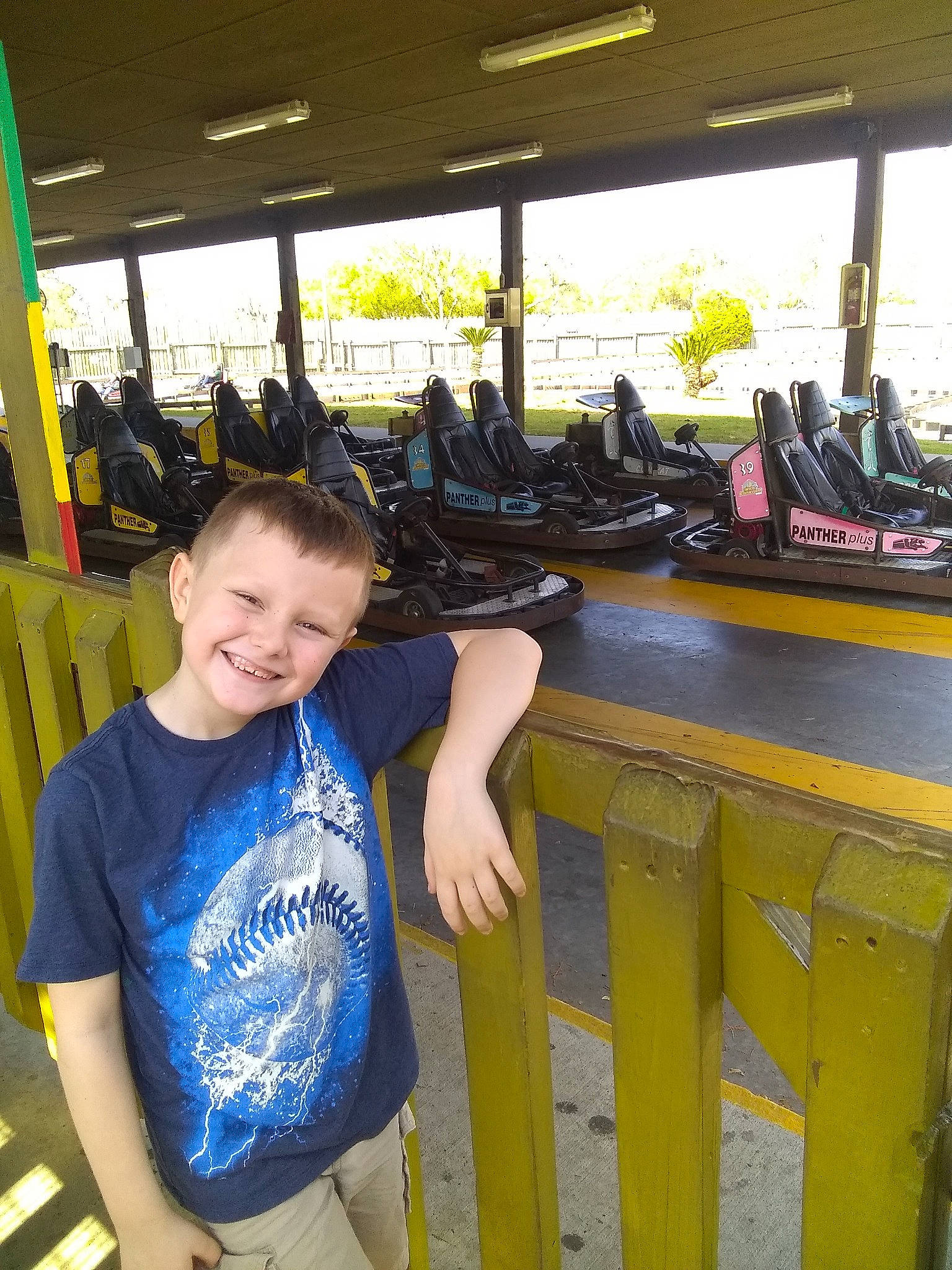 Dartanyn is registered to the contest to win money with this photo: automotive_exterior, automotive_tire, automotive_wheel_system, bumper, electric_blue, fence, fun, happy, joy, leisure, motor_vehicle, nonbuilding_structure, person, personal_protective_equipment, recreation, room, smile, sportswear, t_shirt, toddler