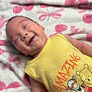 Zhaiden Emiliano is registered to the contest to win money with this photo: baby, smiling, blanket, yellow_tank_top, cartoon_characters, face, infant, happy, cute, child, soft_texture, patterned_blanket, lying_down, indoors, skin, head, clothing, expression, toddler, portrait