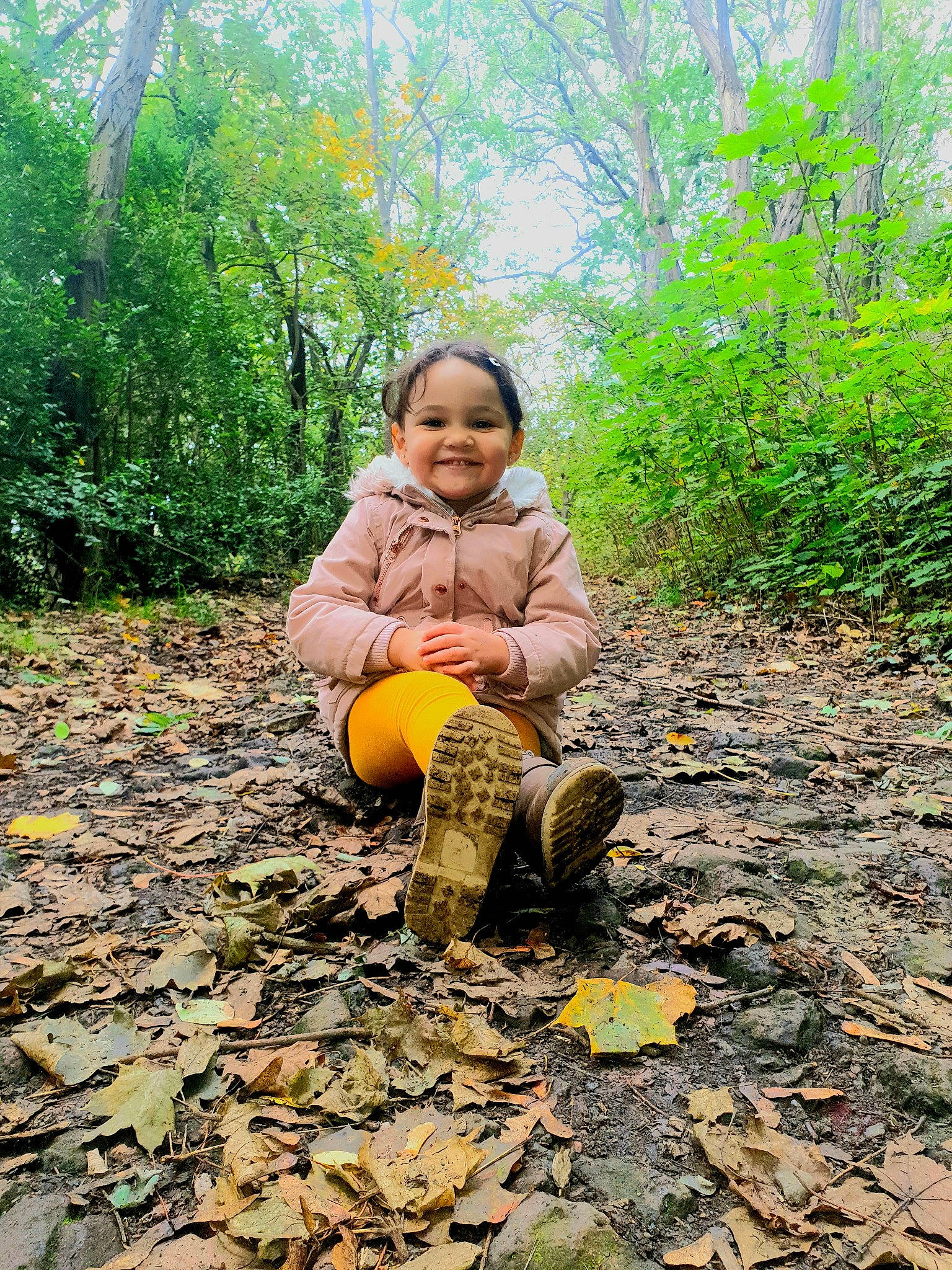 Laila a rejoint le concours — aidez-le/la à gagner de superbes lots ! adaptation, autumn, child, forest, grass, joy, jungle, leaf, mud, people_in_nature, person, plant, play, rock, sitting, smile, soil, toddler, tree, woodland