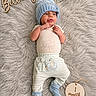 Bellamy joined the competition — help win amazing prizes! baby, newborn, infant, child, portrait, lying_down, blue_hat, winter_clothing, booties, onesie, striped_pants, fluffy_blanket, milestone_photo, one_month, wooden_sign, nursery, cozy, tongue_out, smiling, indoors