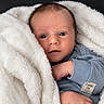 baby, newborn, infant, child, portrait, face, blue_eyes, wide_eyed, looking_at_camera, blanket, white_blanket, blue_clothing, pajamas, sleeve, hand, fist, indoors, cozy, close_up, two_weeks_old