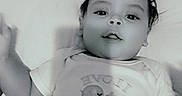 Kayden is registered to the contest to win money with this photo: arm, baby, bedding, black_and_white, child, clothing, cute, elephant, eyes, face, hair, hand, infant, lying_down, mouth, onesie, pillow, portrait, smile, toddler