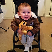 Stan Pillon participe au concours pour gagner de l'argent avec cette photo : toddler, child, stroller, plush_toy, dog_toy, jacket, pacifier, indoor, carpet, door, keys, person, clothing, wheel, baby, cute, seated, face, happy, hand