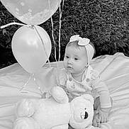Esmée a rejoint le concours — aidez-le/la à gagner de superbes lots ! baby, infant, child, balloons, teddy_bear, plush_toy, headband, blanket, outdoor, hedge, grass, portrait, sitting, cute, gaze, ribbon, party, celebration, black_and_white, photography