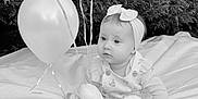 Esmée participe au concours pour gagner de l'argent avec cette photo : baby, infant, child, balloons, teddy_bear, plush_toy, headband, blanket, outdoor, hedge, grass, portrait, sitting, cute, gaze, ribbon, party, celebration, black_and_white, photography
