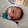 newborn, baby, hospital, medical_equipment, nasal_cannula, blanket, bed, face, infant, patient, healthcare, tubes, curly_hair, lying_down, closeup, fragile, quiet, white, care, medical