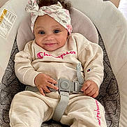 Keyari joined the competition — help win amazing prizes! baby, child, smiling, headband, curly_hair, champion_clothing, socks, baby_seat, seatbelt, cushion, indoor, cute, happy, infant, portrait, comfortable, clothing, hands, feet, person