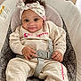 baby, child, smiling, headband, curly_hair, champion_clothing, socks, baby_seat, seatbelt, cushion, indoor, cute, happy, infant, portrait, comfortable, clothing, hands, feet, person