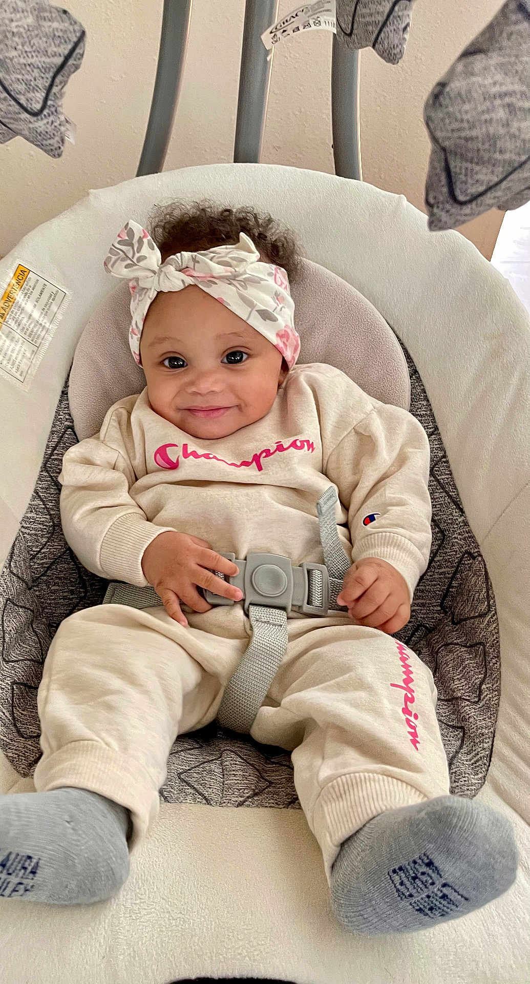 Keyari joined the competition — help win amazing prizes! baby, child, smiling, headband, curly_hair, champion_clothing, socks, baby_seat, seatbelt, cushion, indoor, cute, happy, infant, portrait, comfortable, clothing, hands, feet, person