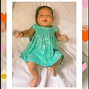 Briana Gutierrez joined the competition — help win amazing prizes! baby, infant, child, portrait, smiling, lying_down, turquoise_dress, heart_pattern, blanket, indoor, close_up, face, hands, bare_feet, soft_lighting, decorative_frame, hearts, flowers, date_text, hashtag