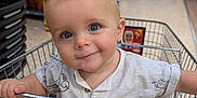 Freddie joined the competition — help win amazing prizes! baby, child, shopping_cart, grocery_store, smiling, blue_eyes, clothing, hand, person, retail, aisle, food, metal, shopping, cute, infant, seat, store, portrait, happy