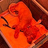 dog, sleeping, puppy, pet, animal, brown_fur, long_hair, basket, crate, laundry_basket, food_bowl, dog_food, blanket, leash, collar, indoor, resting, cozy, closeup, orange_lighting