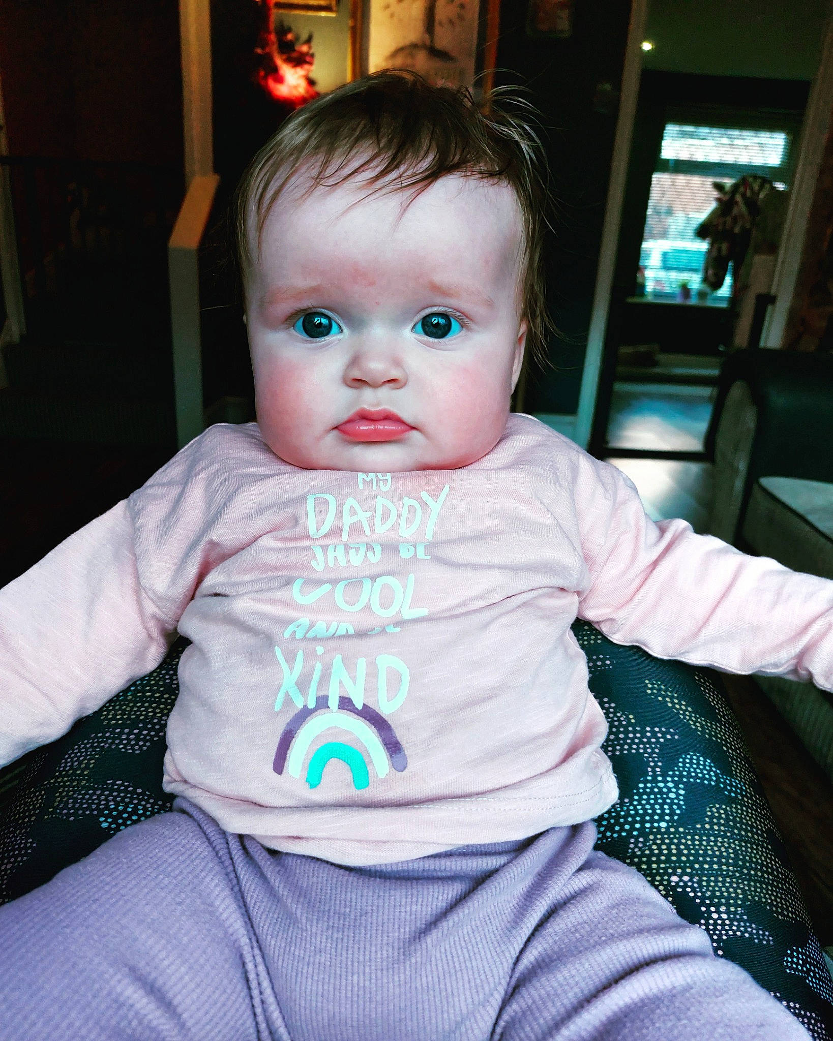 Primrose is registered to the contest to win money with this photo: baby, baby_products, baby_toddler_clothing, chair, cheek, child, electric_blue, eye, fun, head, iris, person, room, sitting, sleeve, t_shirt, toddler, vacation