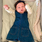 Loëva a rejoint le concours — aidez-le/la à gagner de superbes lots ! baby, infant, denim_dress, headband, blanket, bedding, smile, happy, cute, lying_down, arms_up, padded, cozy, child, portrait, soft, white_clothing, toddler, indoors, face