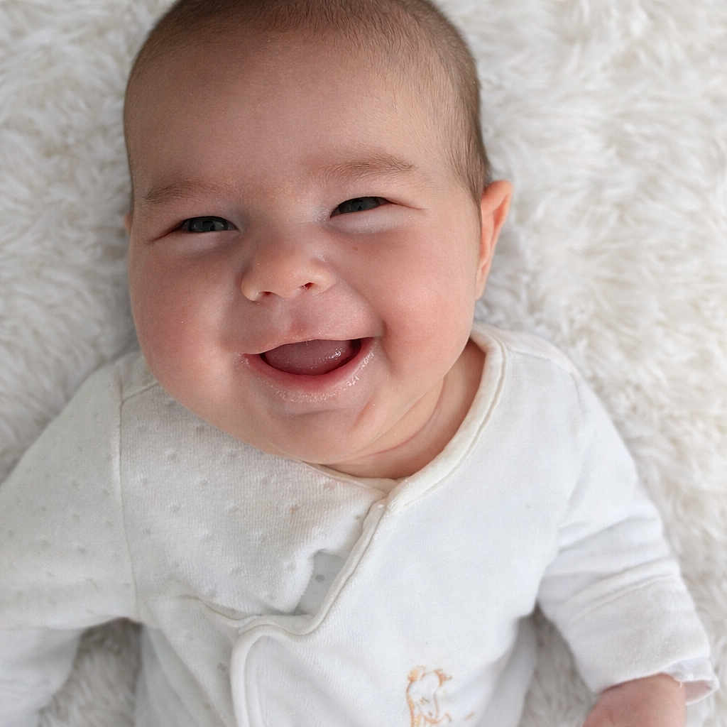 Marius participe au concours pour gagner de l'argent avec cette photo : baby, smile, infant, white_clothing, close_up, face, happy, lying_down, soft_texture, cute, child, young, skin, portrait, baby_girl, baby_boy, newborn, innocence, joy, cozy