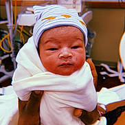 Ja'Karie is registered to the contest to win money with this photo: newborn, baby, infant, wrapped, blanket, hat, striped_hat, hospital, nursery, hands, person, cute, sleepy, face, indoors, medical_equipment, soft, warm, care, child