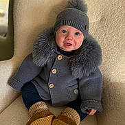 Mack joined the competition — help win amazing prizes! baby, child, knit_hat, pom_pom, gray_sweater, fur_trim, armchair, cozy, warm_clothing, sitting, cute, indoors, soft_texture, legs, baby_booties, smiling, happy, portrait, person, infant