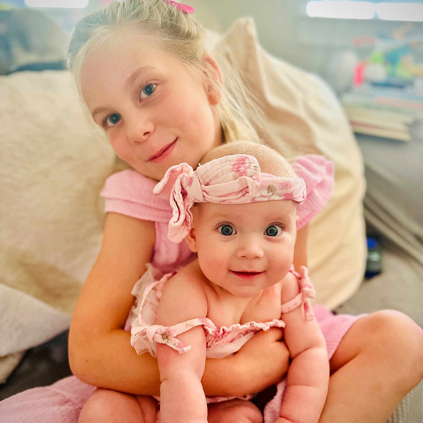 Mari is registered to the contest to win money with this photo: baby, blurry_background, child, couch, cute, family, girl, happy, headband, holding, home, indoor, infant, love, pink_clothing, portrait, sitting, smiling, soft_light, together