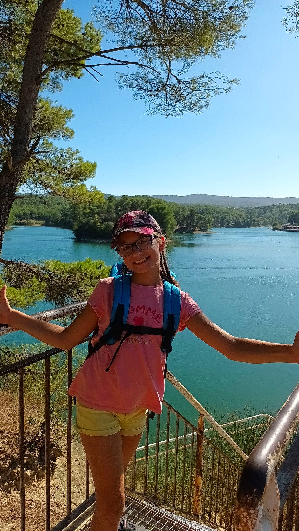 Samantha participe au concours pour gagner de l'argent avec cette photo : botany, electric_blue, fence, fun, happy, headwear, joy, lake, landscape, leisure, people_in_nature, person, plant, recreation, sky, smile, summer, sunglasses, thigh, travel
