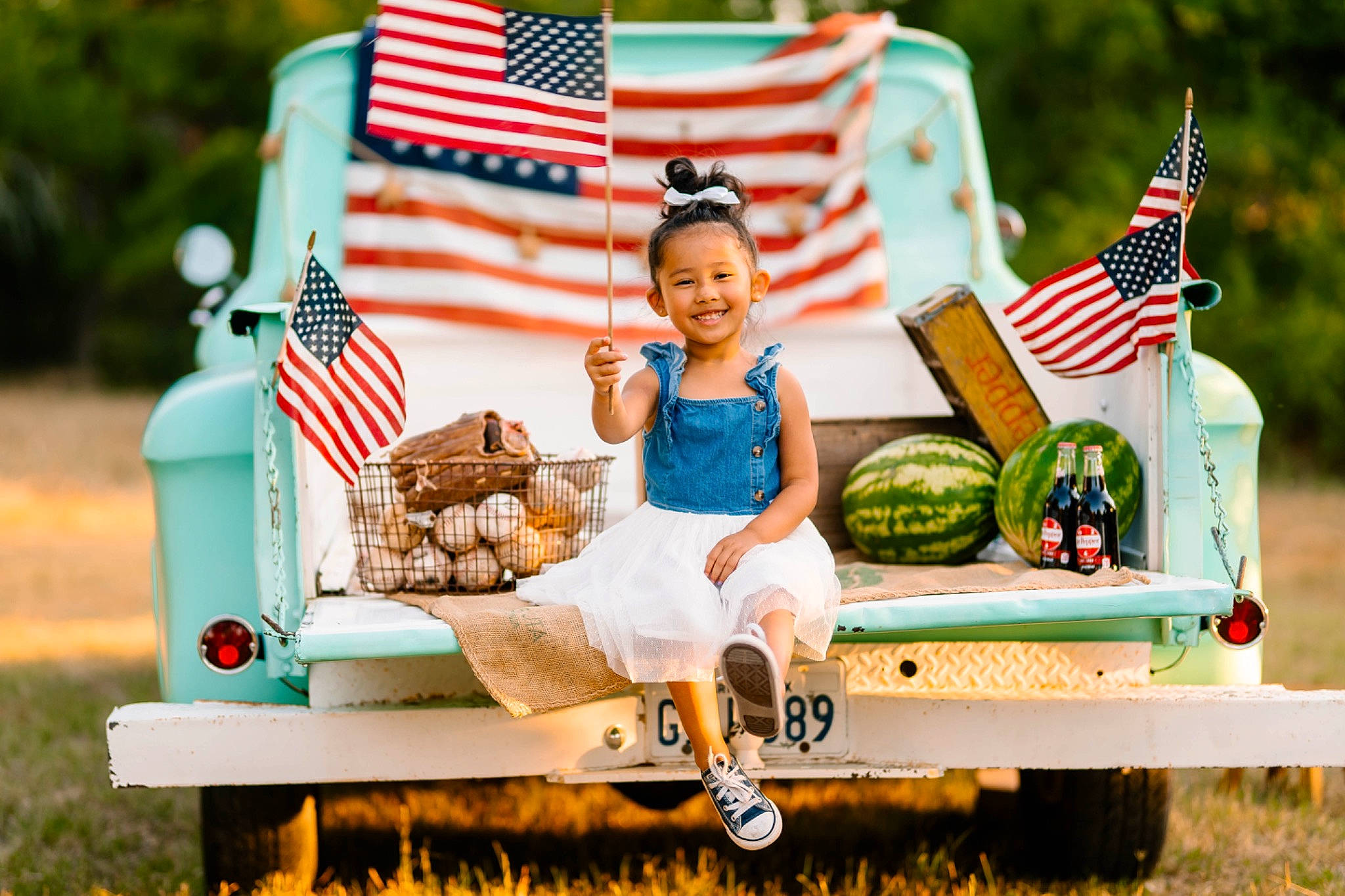 Silvia is registered to the contest to win money with this photo: automotive_wheel_system, child, event, flag, flag_day_usa, flag_of_the_united_states, fun, grass, happy, holiday, joy, leisure, motor_vehicle, person, recreation, sitting, summer, sun_hat, tire, toddler