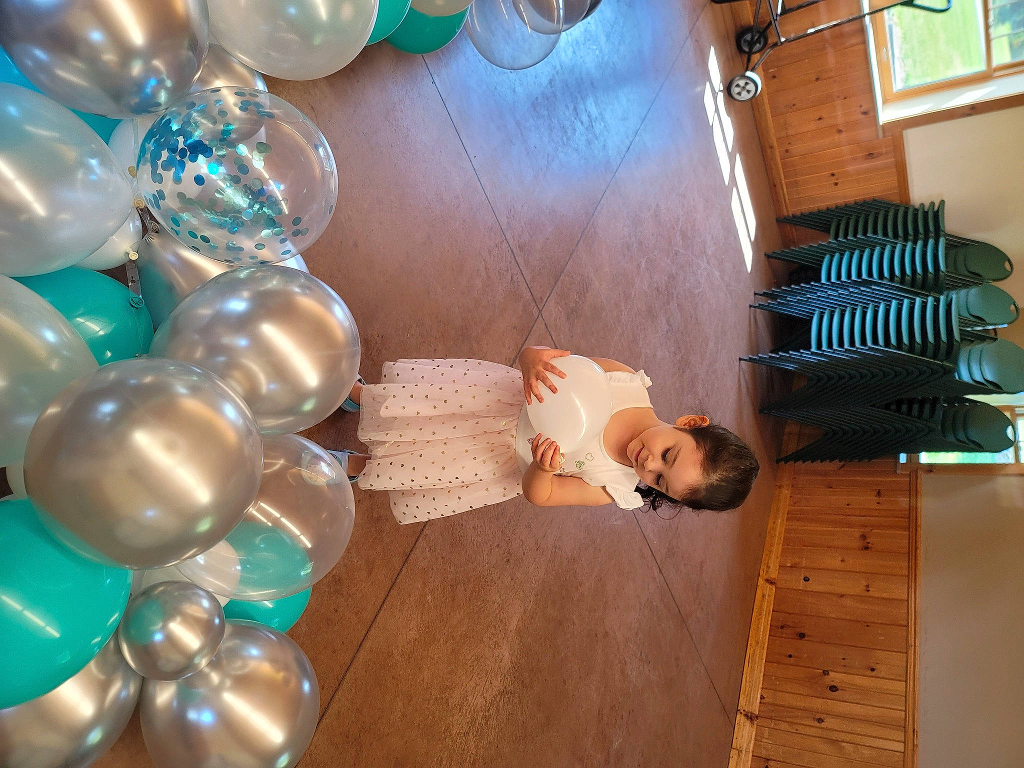 Izabella is registered to the contest to win money with this photo: arch, balloon, blue, child, decoration, drinkware, event, flooring, fun, happy, hardwood, holiday, leisure, living_room, party, party_supply, person, room, sitting, wood