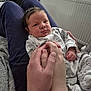 baby, newborn, infant, hands, person, clothing, onesie, lap, indoor, radiator, bedroom, blanket, furniture, skin, face, expression, holding, cute, cozy, resting