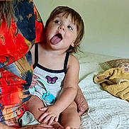 Haisley joined the competition — help win amazing prizes! toddler, child, woman, bed, blanket, hand, tongue, face, expression, colorful_clothing, indoor, people, portrait, skin, hair, holding, sitting, playful, room, adult