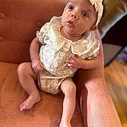 Haisley joined the competition — help win amazing prizes! baby, infant, child, armchair, orange, clothing, headband, lace, buttons, fabric, sitting, indoors, skin, feet, legs, hand, face, eyes, expression, portrait