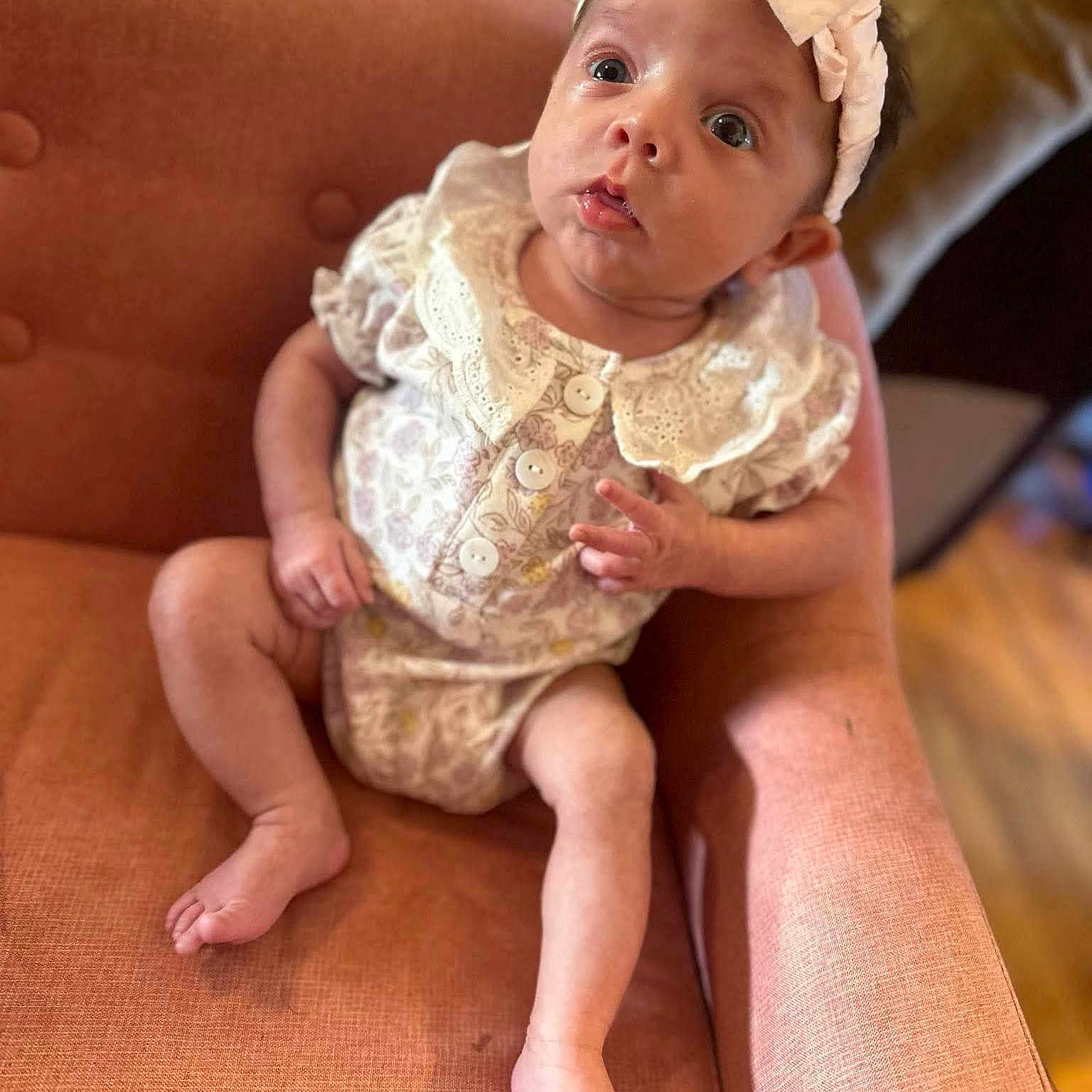 Haisley joined the competition — help win amazing prizes! baby, infant, child, armchair, orange, clothing, headband, lace, buttons, fabric, sitting, indoors, skin, feet, legs, hand, face, eyes, expression, portrait